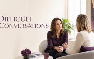 Two professional women having a focused and respectful conversation in a bright office, illustrating courageous leadership and difficult conversations.